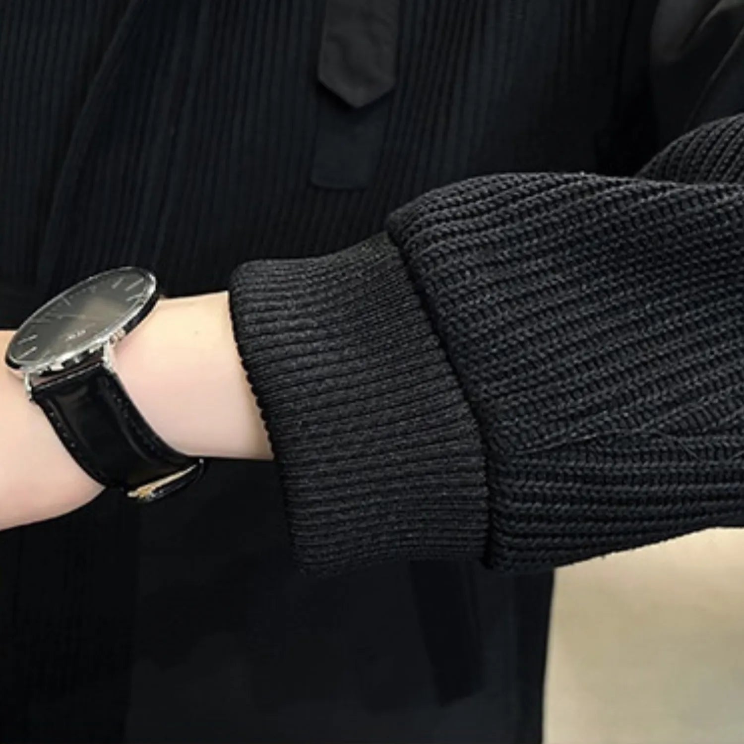 Close-up of the men's knitted coat cuff, showcasing the ribbed texture and a comfortable fit.