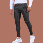 Model wearing Baltere's Men's Slim Fit Business Trousers, showcasing the modern tapered leg and versatile business-casual style in dark gray.