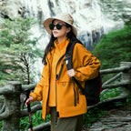 Model wearing Baltere's Women's 3-in-1 Waterproof Jacket yellow, made from durable polyester, showcasing the hooded design and dual-layer system.