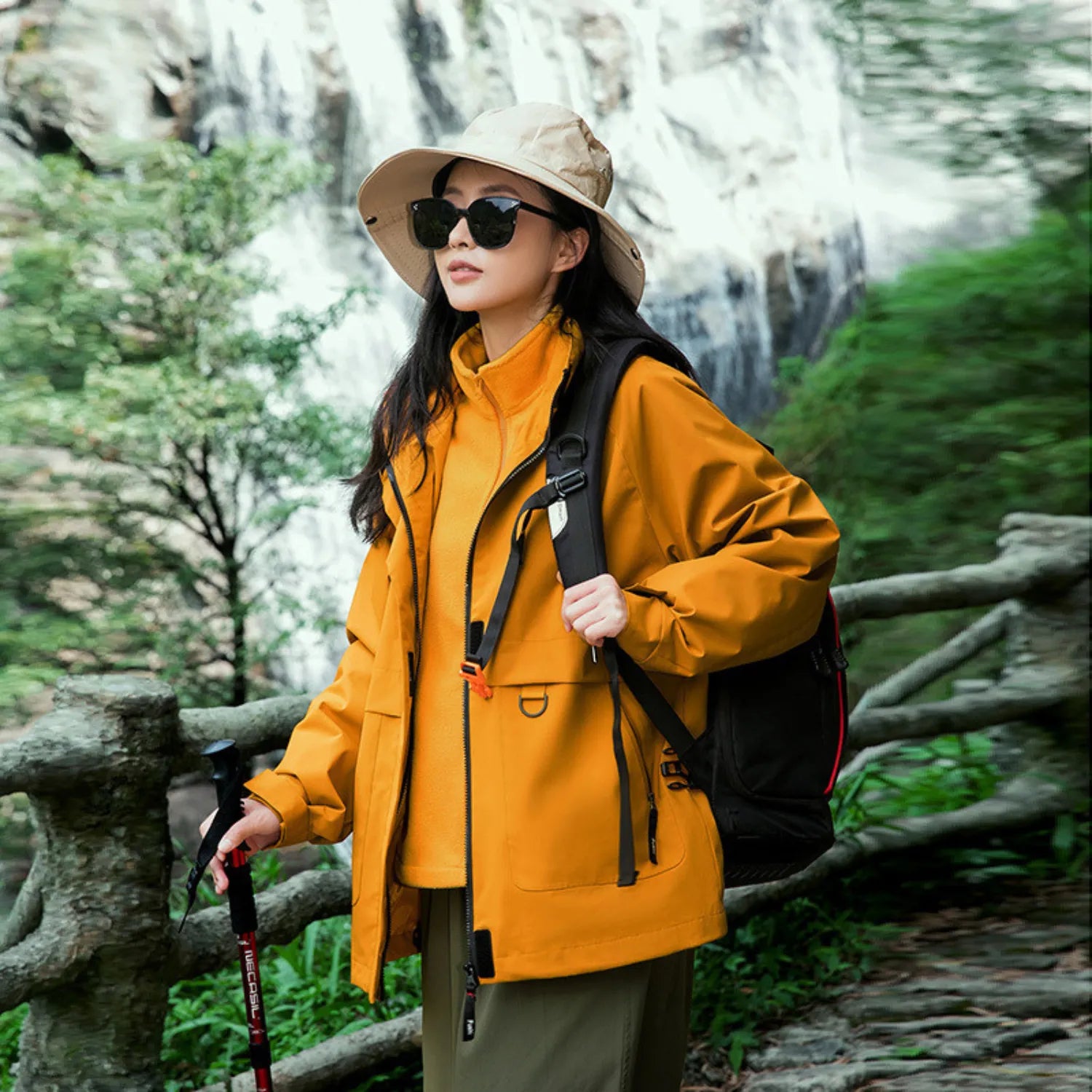 Model wearing Baltere's Women's 3-in-1 Waterproof Jacket yellow, made from durable polyester, showcasing the hooded design and dual-layer system.