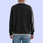 Rear view of Baltere's Contrast Color Pullover Sweater black, showcasing the relaxed fit, ribbed hem, and contrast trim details on the cuffs and bottom.