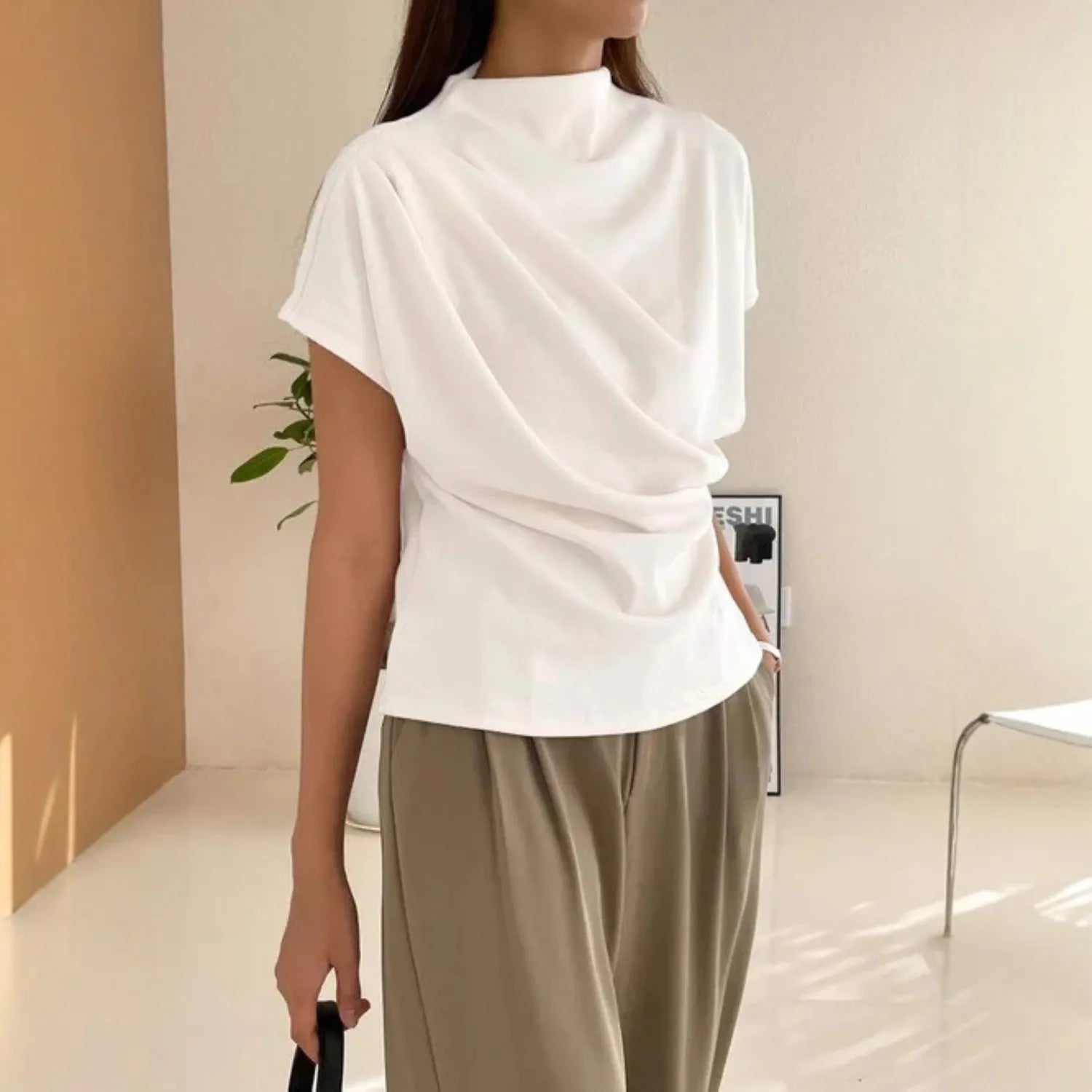 Model wearing the Baltere Draping Top, showcasing the flattering silhouette, in white.