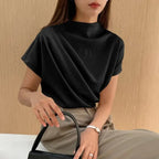 Model wearing Baltere's Draping Short Sleeve Pullover Top, in black, showcasing the elegant cowl neckline.
