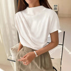 Model wearing the Baltere Draping Top white, showcasing the flattering silhouette.
