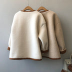 Rear view of two variants of the Baltere sherpa coat on hangers, highlighting the different textured finishes and contrasting trim.