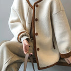 Detailed view of the women's East Asian Inspired Sherpa Coat, highlighting the contrasting trim, front buttons.