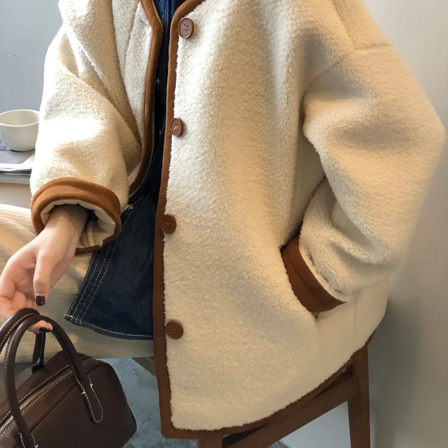 Detailed view of the women's East Asian Inspired Sherpa Coat, highlighting the contrasting trim, front buttons, and cozy faux fur texture.