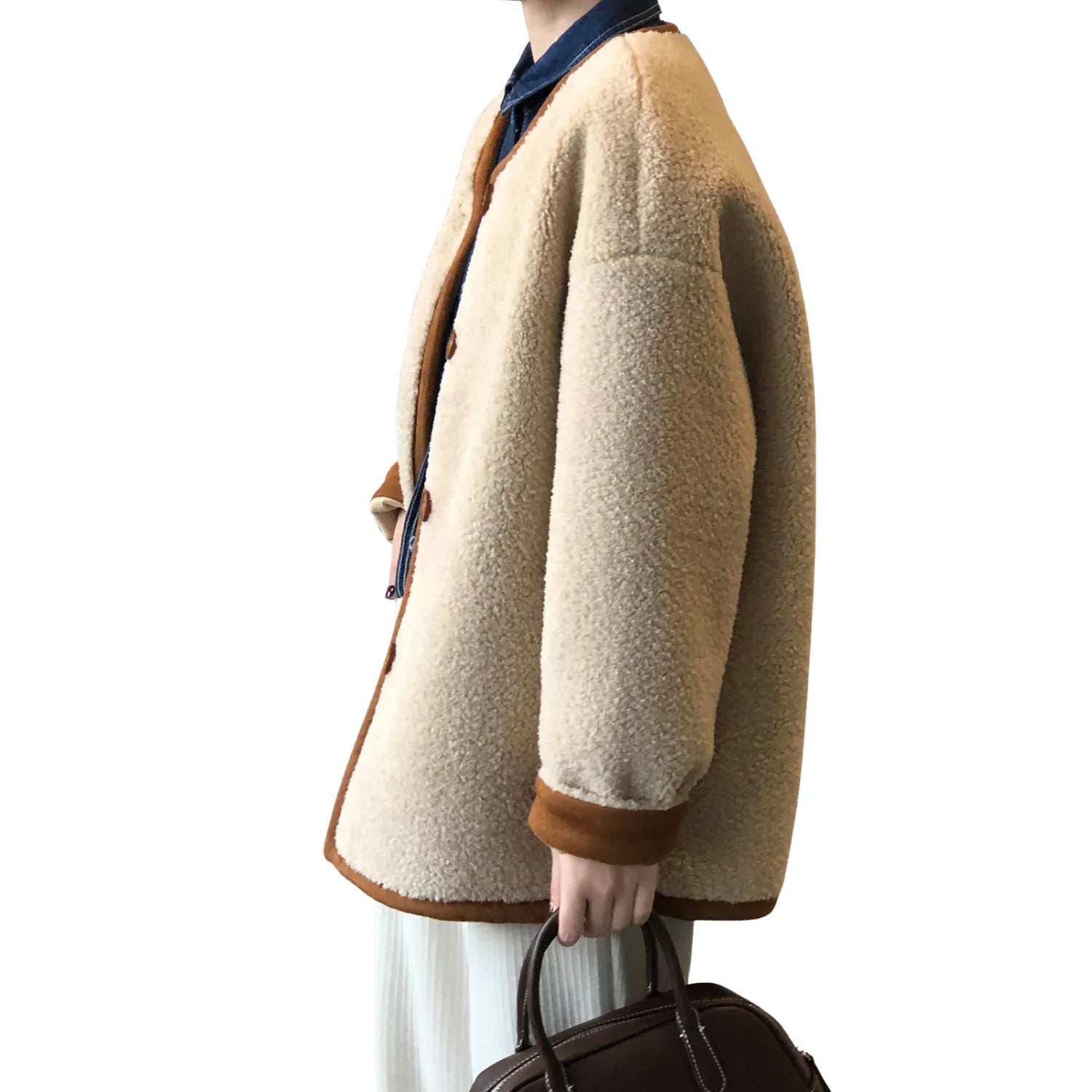 Model wearing Baltere's cozy sherpa coat, highlighting the contrasting trim, full-length sleeves, and button-up front.