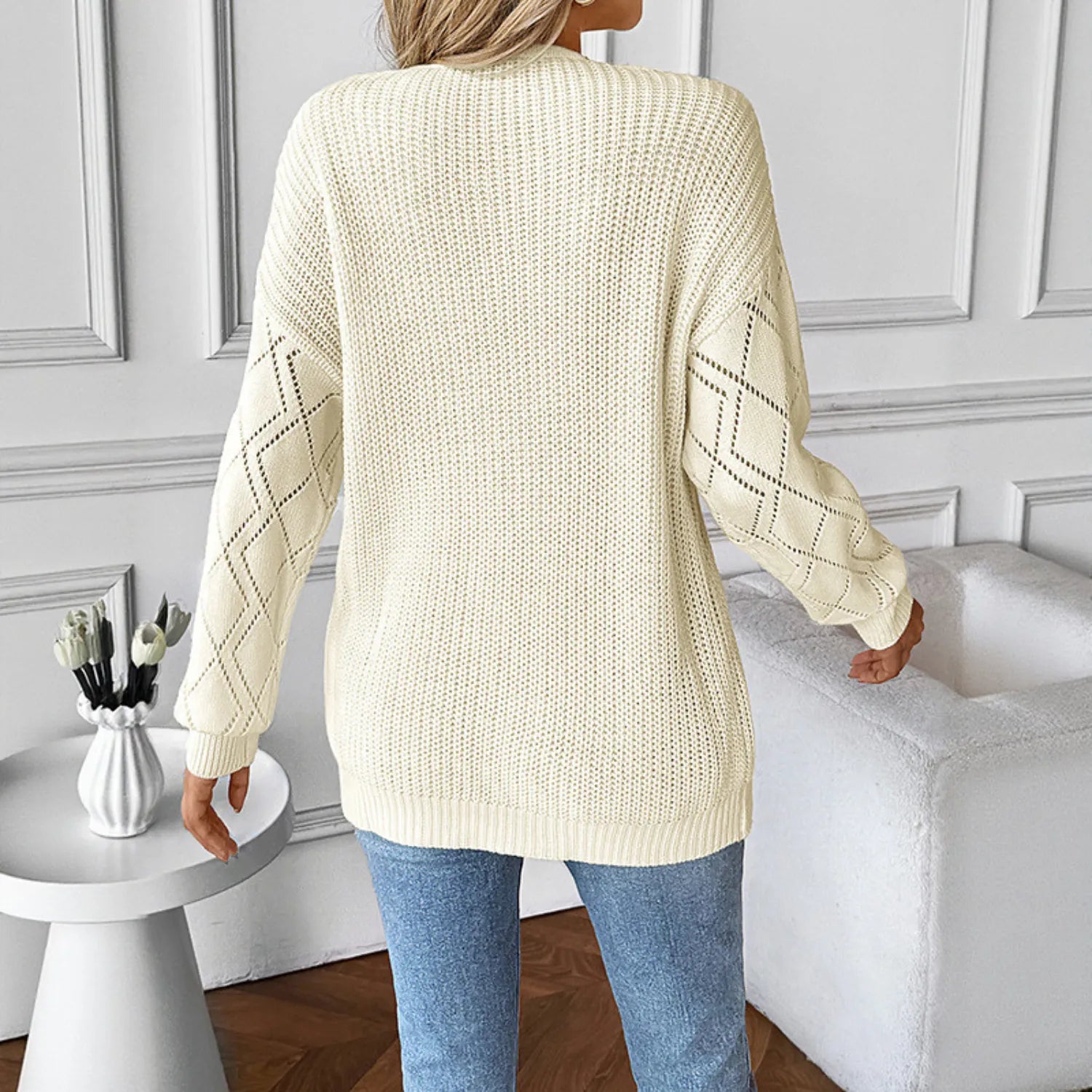 Rear view of Baltere's Elegant Pullover Sweater, showcasing its relaxed fit and unique open knit pattern on the sleeves.