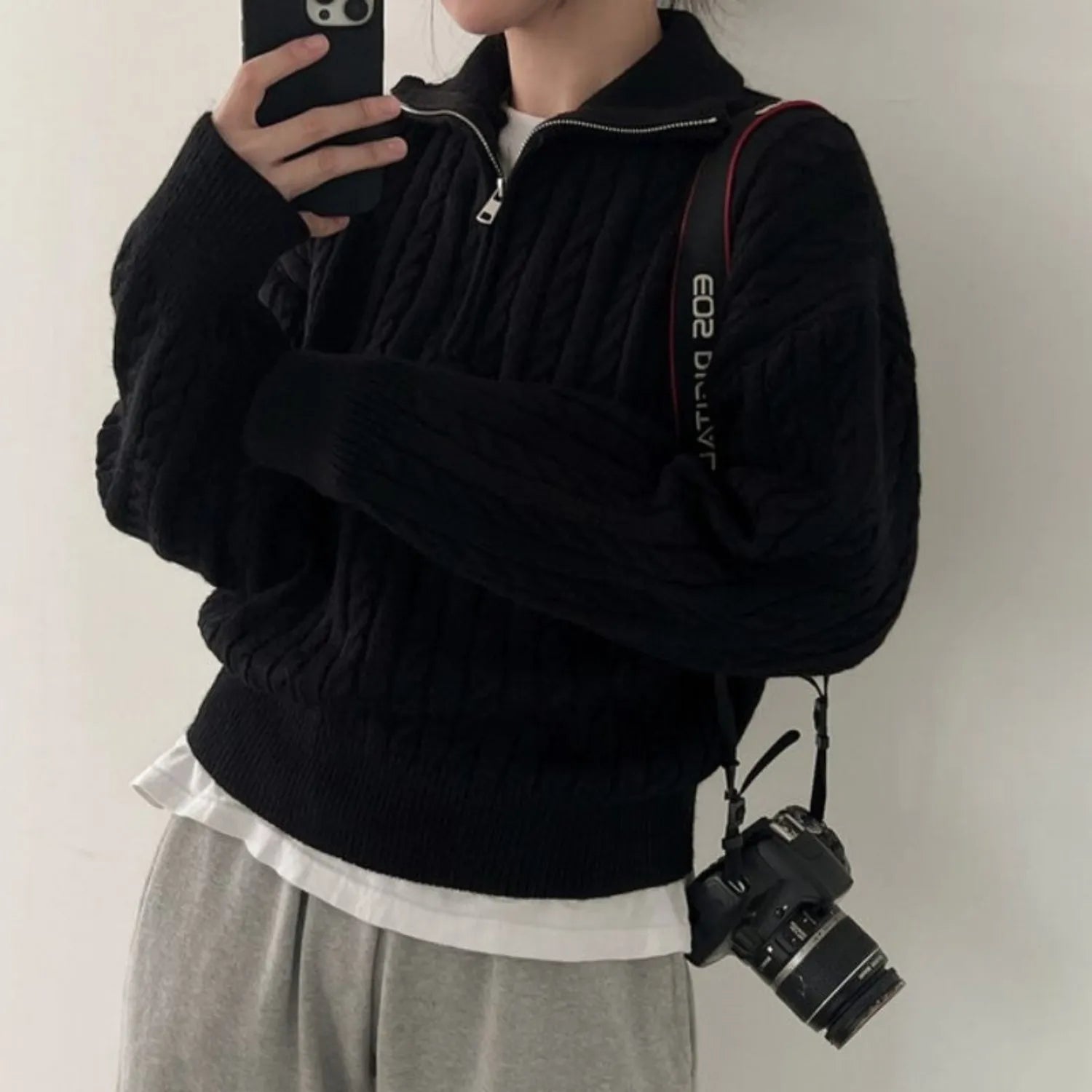Model wearing Baltere's Women's High-Collar Zipper Pullover Top, showcasing its modern high-collar design and quarter-zip feature in black.
