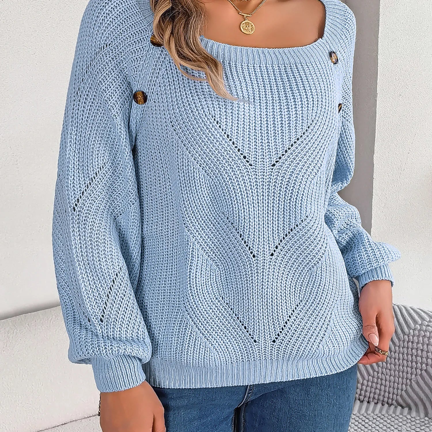 Baltere's cozy sweater light blue, highlighting the comfortable loose fit and decorative side buttons.