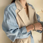 Model wearing the Baltere Trench Coat, emphasizing the oversized lapel and elegant, cinched-waist fit, in beige.