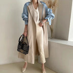 Women's Retro Lapel Trench Coat, highlighting the contrasting fabric panels, deep pockets, and long, in beige.