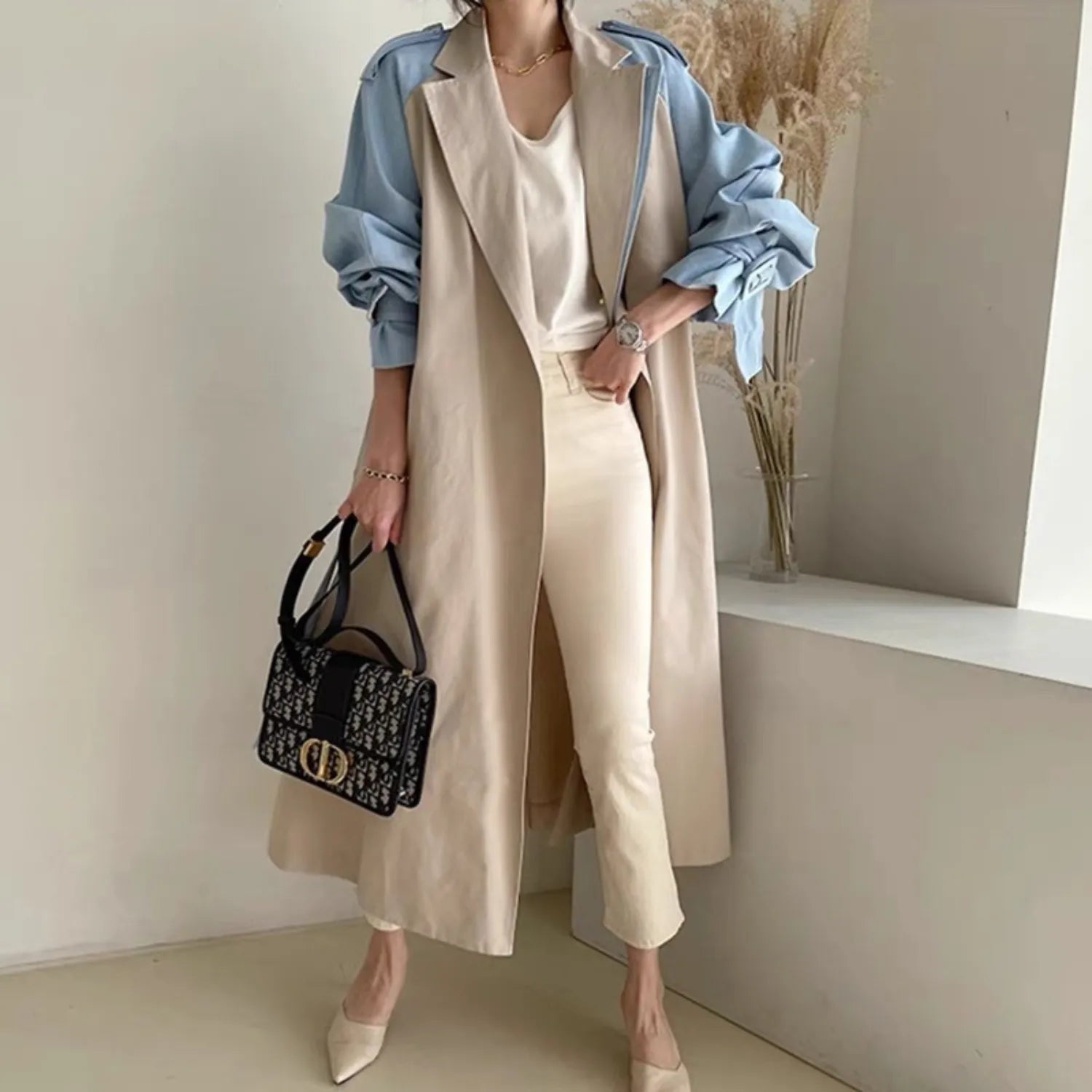 Women's Retro Lapel Trench Coat, highlighting the contrasting fabric panels, deep pockets, and long, in beige.